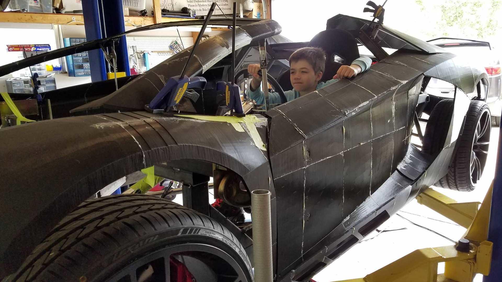 Syn sedící za volantem automobilu Lamborghini Aventador, který si s jeho otcem tisknout na 3D tiskárně Syn sedící za volantem automobilu Lamborghini Aventador, který si s jeho otcem tisknout na 3D tiskárně