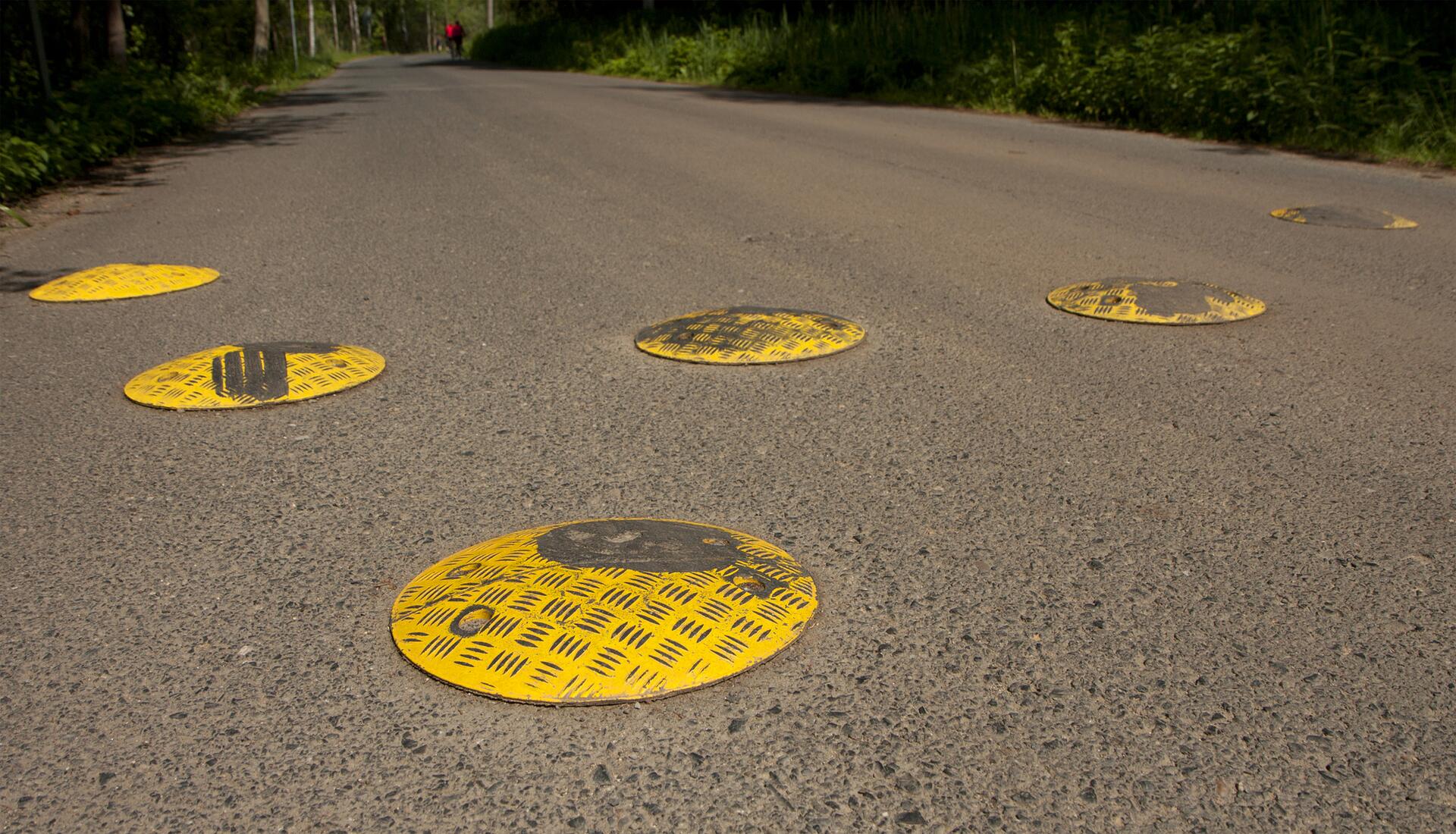 Malé kruhové žluté zpomalovače na silnici